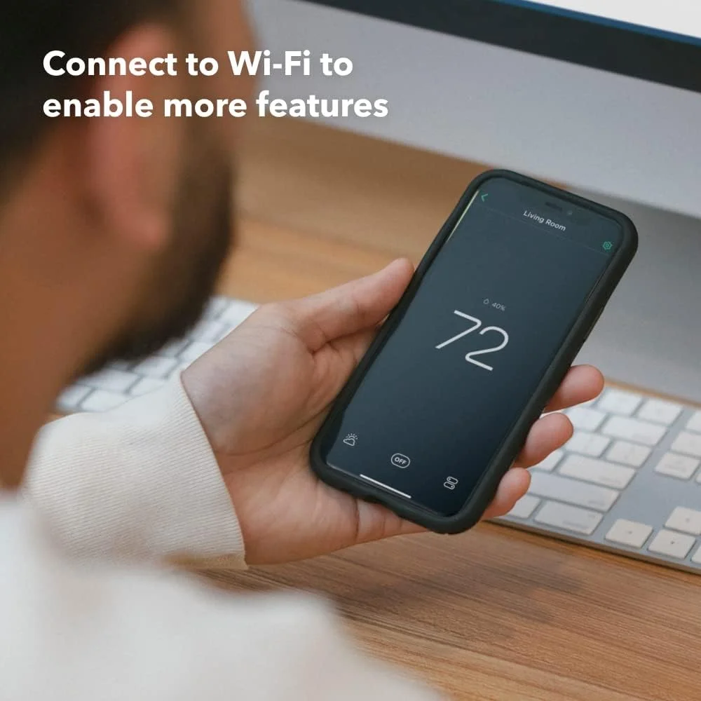 Man using smartphone to control Ecobee Smart Premium Thermostat via Wi-Fi in Dubai
