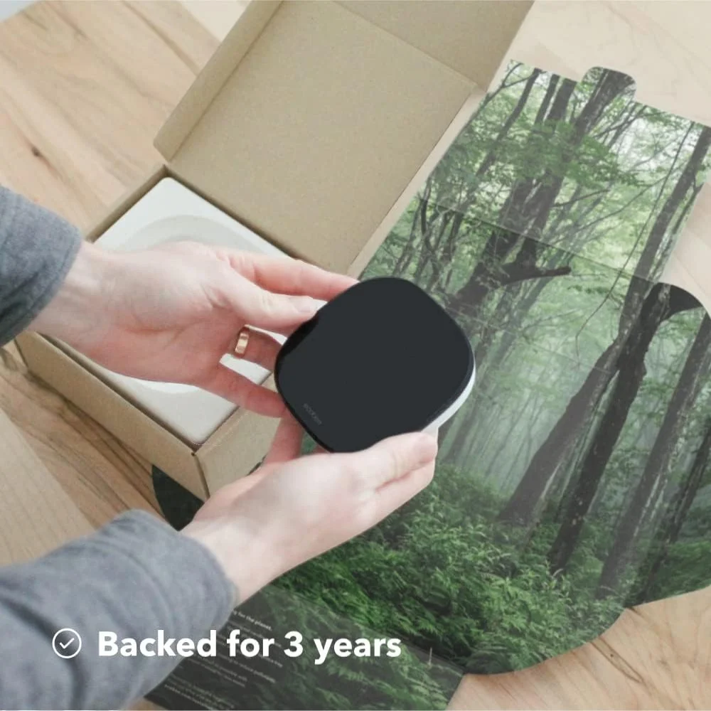 Hands holding Ecobee Smart Thermostat Enhanced with packaging